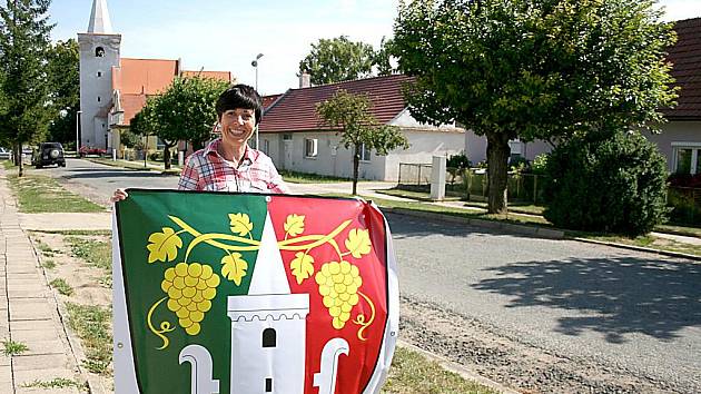 USMĚVAVÁ STAROSTKA. Práce na radnici Barboru Arndt baví a je to vidět. Úsměv z tváře jí téměř nemizí. Na snímku ukazuje novou vlajku se znakem obce.