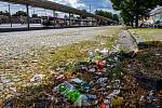 Cestující a kolemjdoucí si všímají nepořádku panujícího v blízkosti starého autobusového nádraží ve Znojmě. Po zemi se válí plastové lahve, kelímky od kávy a další odpadky.