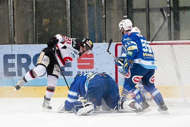 Hokejista Petr Beránek (v černobílém) střílí gól.