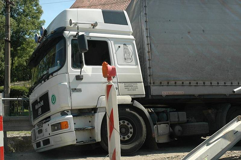 Kamion naložený hutním materiálem se pokoušel projet po provizorním mostě ve Volfarticích. Utrhla se s ním krajnice a museli jej vyprostit jeřábem. 