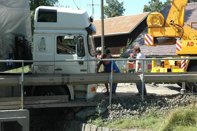 Kamion naložený hutním materiálem se pokoušel projet po provizorním mostě ve Volfarticích. Utrhla se s ním krajnice a museli jej vyprostit jeřábem. 
