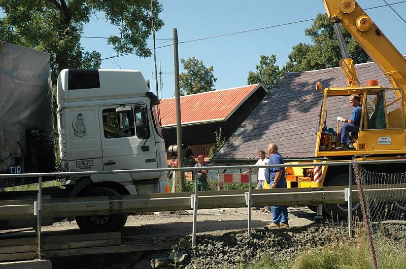 Kamion naložený hutním materiálem se pokoušel projet po provizorním mostě ve Volfarticích. Utrhla se s ním krajnice a museli jej vyprostit jeřábem. 