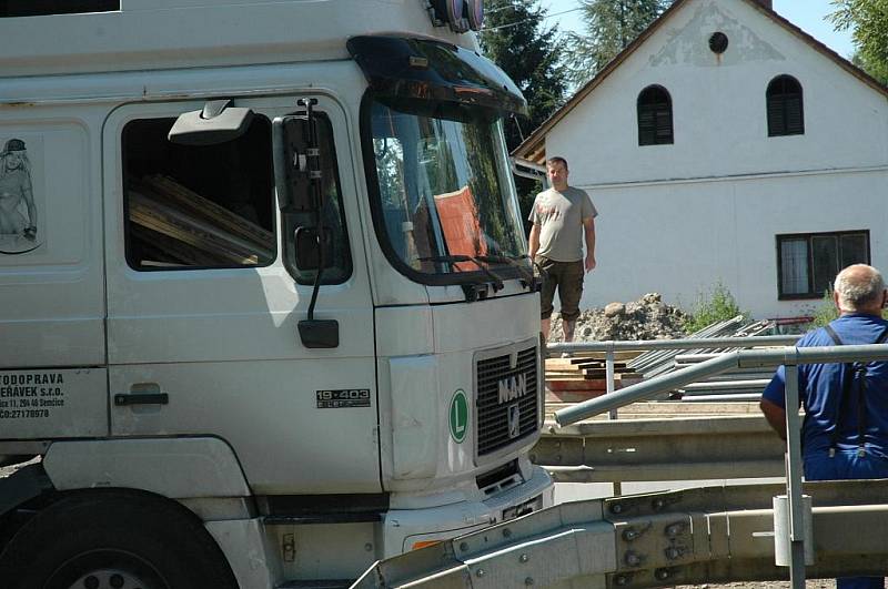 Kamion naložený hutním materiálem se pokoušel projet po provizorním mostě ve Volfarticích. Utrhla se s ním krajnice a museli jej vyprostit jeřábem. 