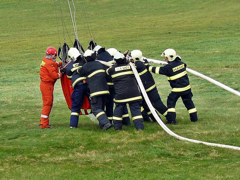 Hasiči, kteří nacvičovali plnění vaku zavěšeného pod policejním vrtulníkem, bojovali s větrem. Plnění osmi set litry vody za pomoci speciální proudnice trvalo asi tři minuty, pak další kolegové naváděli stroj na cíl. 