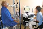 Pacient  usazený ve vyšetřovací kabině bodypletysmografu provádí různé dechové manévry podle pokynů zdravotní sestry.