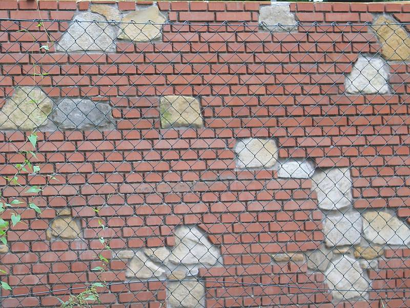 Moderní cihlovou zeď prokládají staré kameny. Lidem se to ale nelíbí.