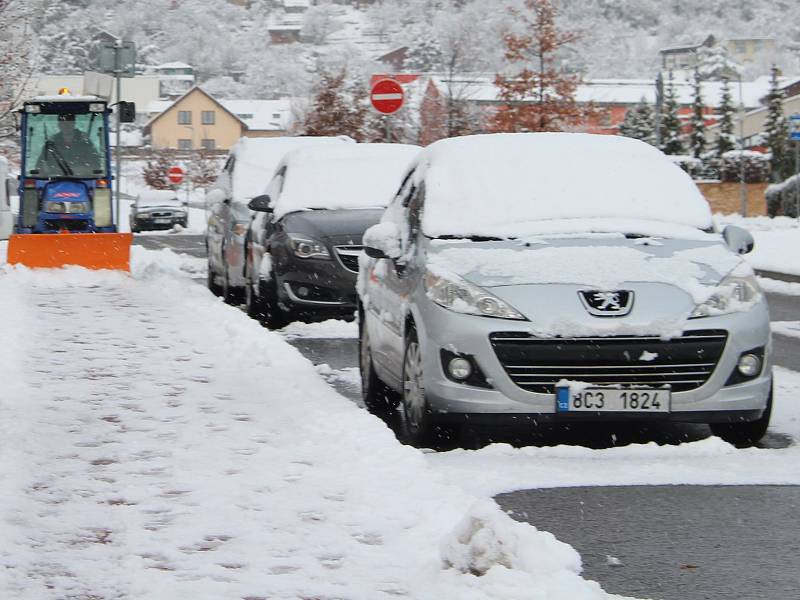 Parkování aut na zasněžených ulicích.