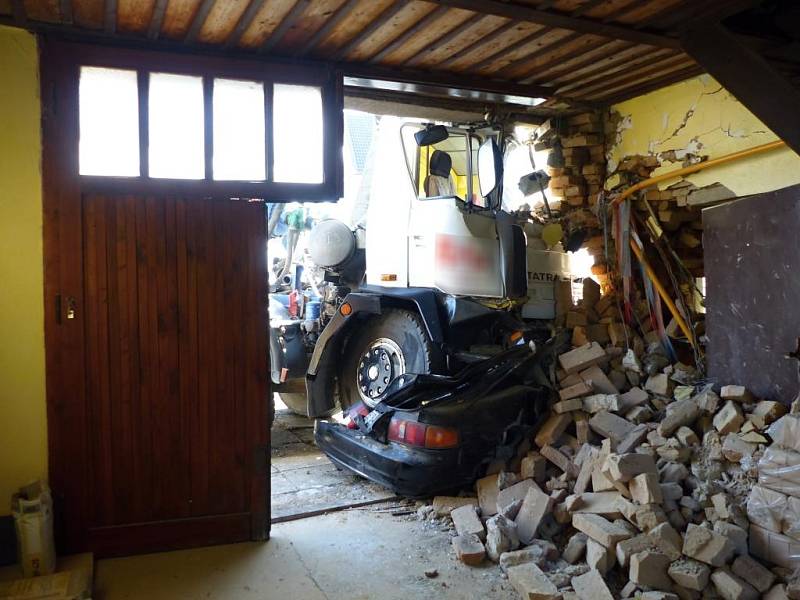 Míchačka slisovala auto v Brankovicích na Vyškovsku a ještě nabourala rodinný dům. Hasiči museli budovu zajistit.