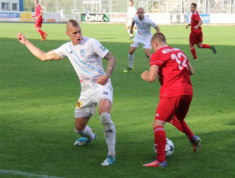 Frýdecko-místečtí fotbalisté (v bílém) byli v derby šťastnější, když díky Biolkovy hlavičky zvítězili nad Třincem 1:0.