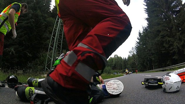 Poskytování první pomoci zraněnému motorkáři. 