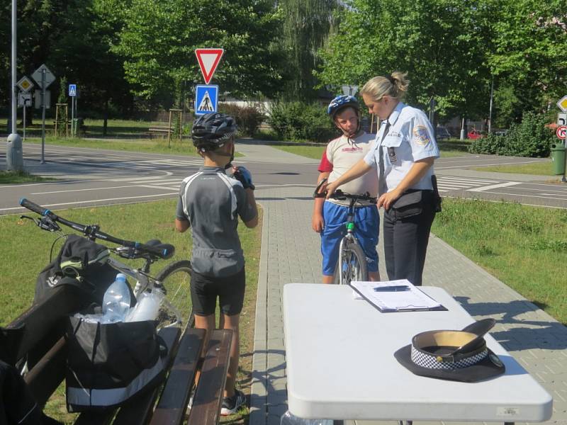 Policisté dětem na dopravním hřišti připomínali, že jízda bez cyklistické helmy je nebezpečná. 