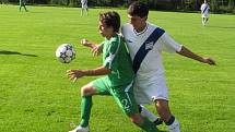 Vlevo karlovický David Minarčík (v zeleném) bojuje o míč s frýdeckým obráncem Michalem Švrčkem.