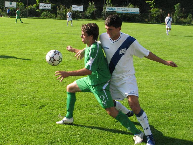 Vlevo karlovický David Minarčík (v zeleném) bojuje o míč s frýdeckým obráncem Michalem Švrčkem.