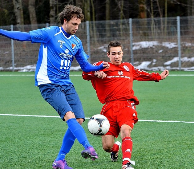 Domácí Martin Sporysz zastavuje faulem hostujícího fotbalistu.