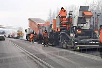 Oprava asfaltového povrchu na silnici I/11 vedoucí na Slovensko kolem Mostů u Jablunkov, únor 2023.