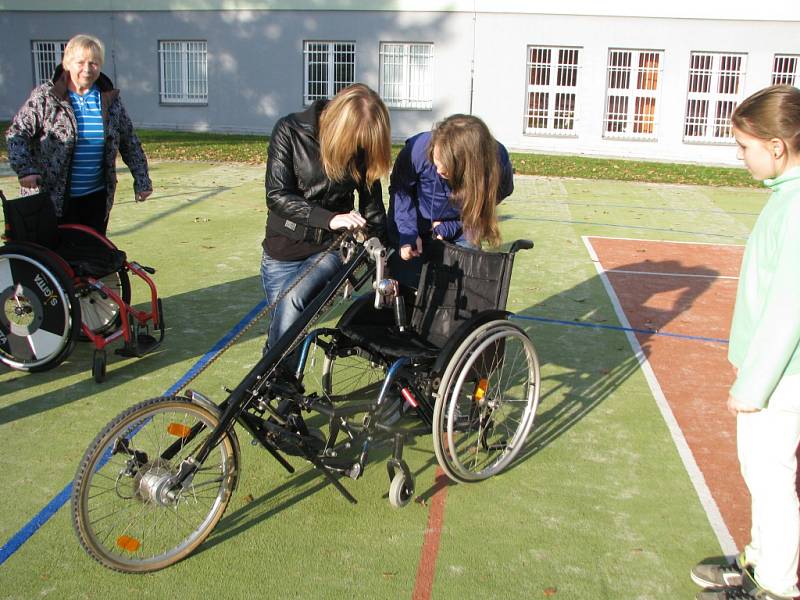 Předání sportovního invalidního vozíku postižené studentce. 