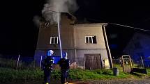 Hasiči při hašení požáru domu v Petřvaldě. 