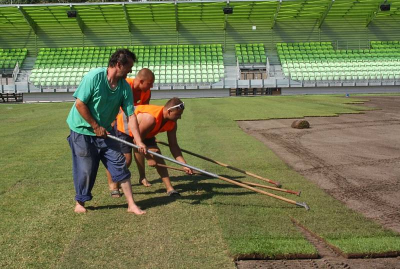 Stavba nového fotbalového stadionu v Karviné finišuje. Kromě dokončovacích prací vně i před areálem dělníci pokládají nový trávník na hřiště. 