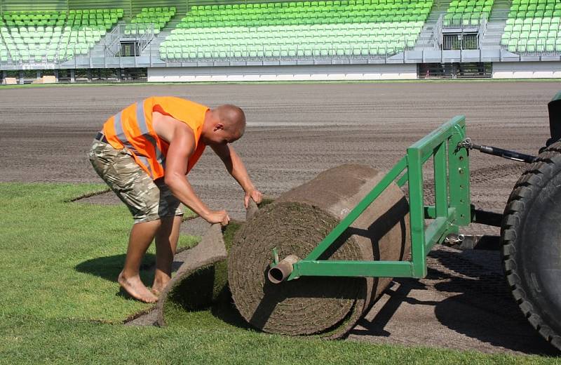 Stavba nového fotbalového stadionu v Karviné finišuje. Kromě dokončovacích prací vně i před areálem dělníci pokládají nový trávník na hřiště. 