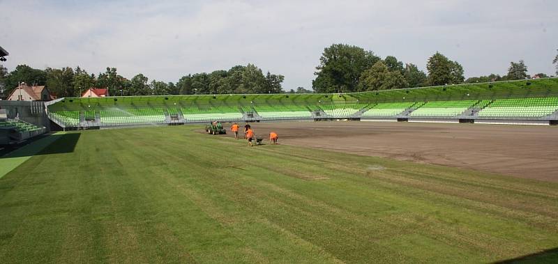 Stavba nového fotbalového stadionu v Karviné finišuje. Kromě dokončovacích prací vně i před areálem dělníci pokládají nový trávník na hřiště. 