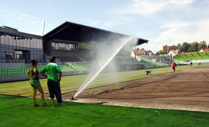 Stavba nového fotbalového stadionu v Karviné finišuje. Kromě dokončovacích prací vně i před areálem dělníci pokládají nový trávník na hřiště. 