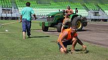 Stavba nového fotbalového stadionu v Karviné finišuje. Kromě dokončovacích prací vně i před areálem dělníci pokládají nový trávník na hřiště. 