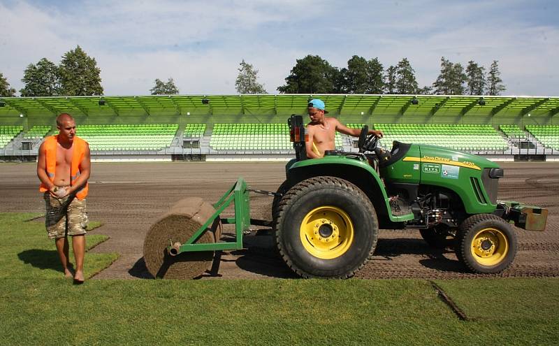 Stavba nového fotbalového stadionu v Karviné finišuje. Kromě dokončovacích prací vně i před areálem dělníci pokládají nový trávník na hřiště. 