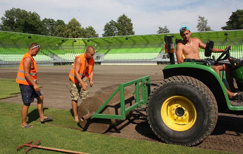 Stavba nového fotbalového stadionu v Karviné finišuje. Kromě dokončovacích prací vně i před areálem dělníci pokládají nový trávník na hřiště. 