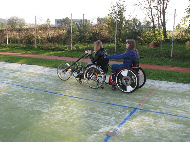 Předání sportovního invalidního vozíku postižené studentce. 