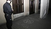 Strážník si prohlíží nápisy a symboly u havířovského kostela. 