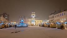 Uzavřené stánky na Masarykově náměstí v Karviné. Vánočně osvětlená historická budova radnice.