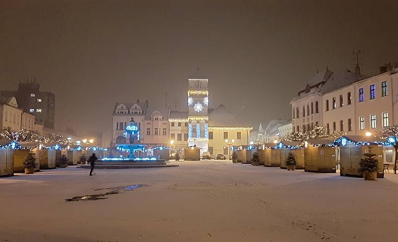 Uzavřené stánky na Masarykově náměstí v Karviné. Vánočně osvětlená historická budova radnice.