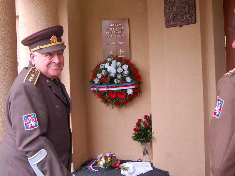 Jeden z politických vězňů položil květiny před odhalenou bronzovou pamětní deskou věnovanou obětem politické perzekuce komunistického režimu.  