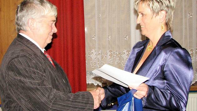 Starostka města Šenova Darja Kuchařová předává ocenění bývalému šenovskému starostovi Karlu Houdkovi.  