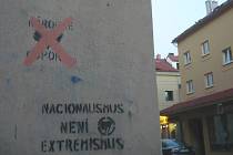 Roh ulice Růžová a U pošty. Červeně přeškrtnuté logo neonacistického Národního odporu nastříkané na fasádě hlavní pošty.