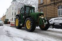 Traktor s radlicí upravuje cestu na Denisově náměstí v Opavě.