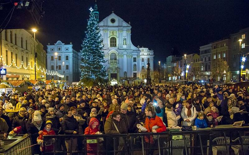 S úderem šesté hodiny se první koleda Nesem vám noviny začala zpívat také na Dolním náměstí v Opavě. Nemohl ji uvést nikdo jiný než známý sbormistr z Nového Dvora Karel Kostera, jenž na pódiu vedl členy stěbořického a také opavského sboru. 