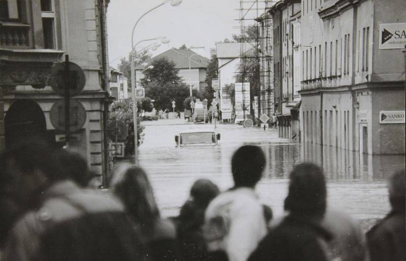 Shromážděný dav před Nákladní ulicí. Vzadu je vidět voda v ulici Pekařské.