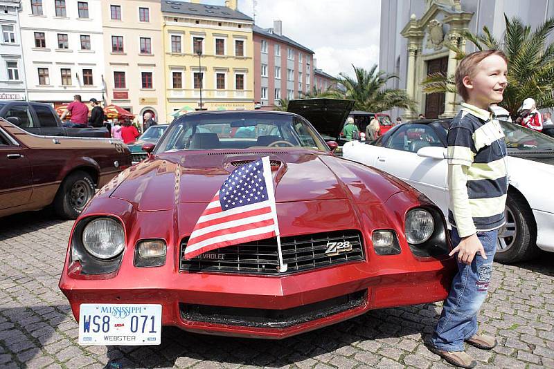 V sobotním odpoledním slunci, které po vytrvalých deštích vylákalo ven stovky lidí, se na Dolním náměstí leskly málo vídané automobily značek Buick, Chevrolet, Ford, Chrysler, Jeep a dalších, nechyběly ani legendární motocykly Harley Davidson.