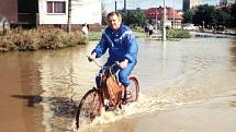 Povodně ustupují. Fotograf zachytil Opavana v Zeyerově ulici v Kateřinkách, když kolem něj projížděl na kole.