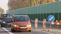 Řidiči projíždějí kolem nové protihlukové zdi na Rolnické ulici. Stále je zde zdržují semafory.