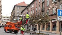 Pracovníci technických služeb zavěšují vánoční ozdoby na Hrčířské ulici v Opavě.
