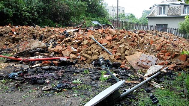 Cedulky Zákaz vstupu. Ticho. Klid. Ani ptáci sem nelétají. I méně citlivý nos cítí spáleninu. Tady stál vítkovský dům číslo 58. Hromada stavební suti, několik ohořelých trámů, satelitní anténa v trávě, ohněm zčernalé nůžky, támhle leží bota. 