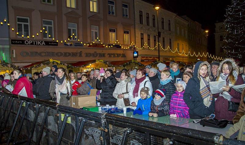 S úderem šesté hodiny se první koleda Nesem vám noviny začala zpívat také na Dolním náměstí v Opavě. Nemohl ji uvést nikdo jiný než známý sbormistr z Nového Dvora Karel Kostera, jenž na pódiu vedl členy stěbořického a také opavského sboru. 