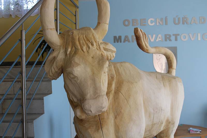 Dřevěná socha býka u vstupu na úřad.