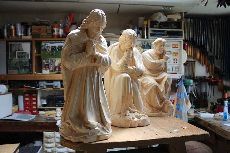 Řezbář František Nedomlel vyřezává nové sochy pro biblický výjev modlícího se Ježíše v Getsemanské zahradě.
