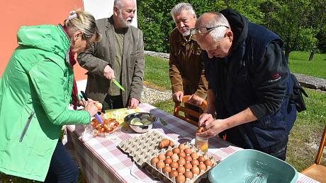 Tradiční Svatodušní vaječinu si farníci uvařili v kotlíku před kostelem v Holčovicích.