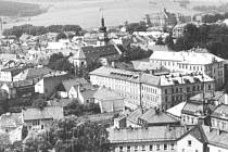 Revoluční ulice v Bruntále okolo roku 1960. Před budovou obchodní akademie ještě nestál bytový dům, stará zástavba šla později k zemi.