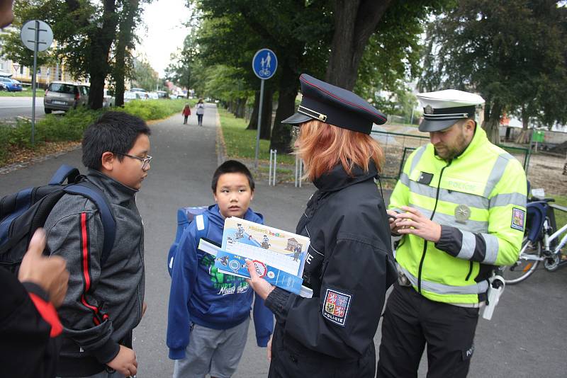 Dopravní policisté s policejní preventistkou a zástupcem BESIPu u základní školy na Dvořákově okruhu v Krnově radili dětem, jak bezpečně přecházet přes silnici.