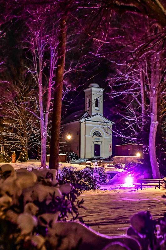 Večerní Karlova Studánka bez lidí a s vánoční nasvícenou atmosférou.